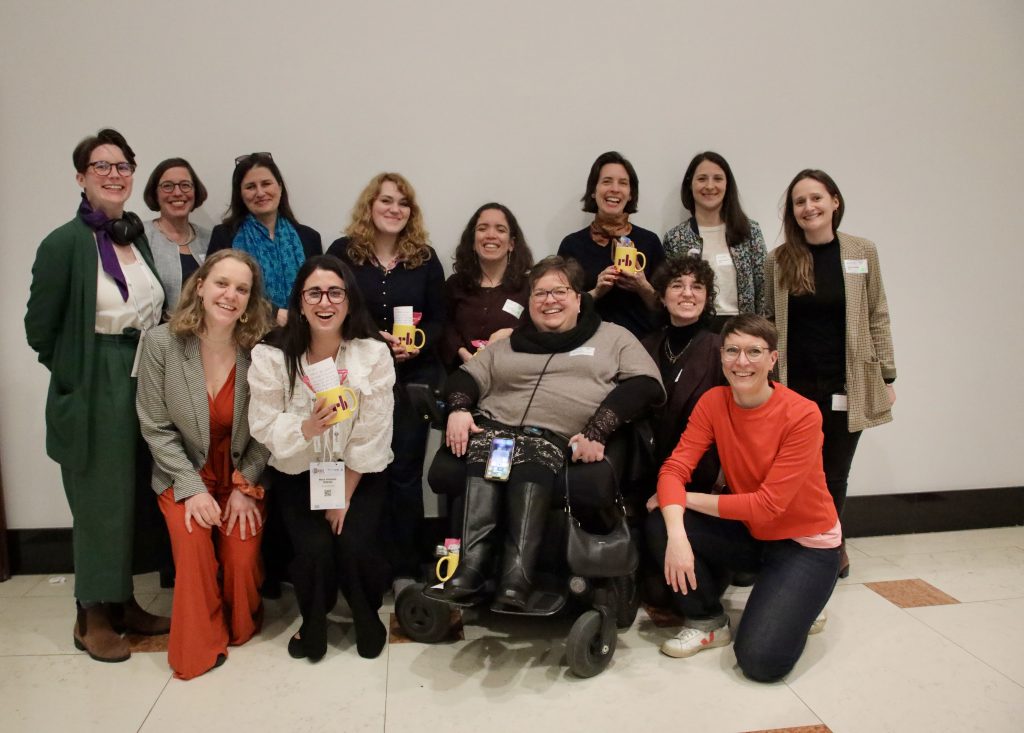 A group of people are standing in front of a wall for a photo.